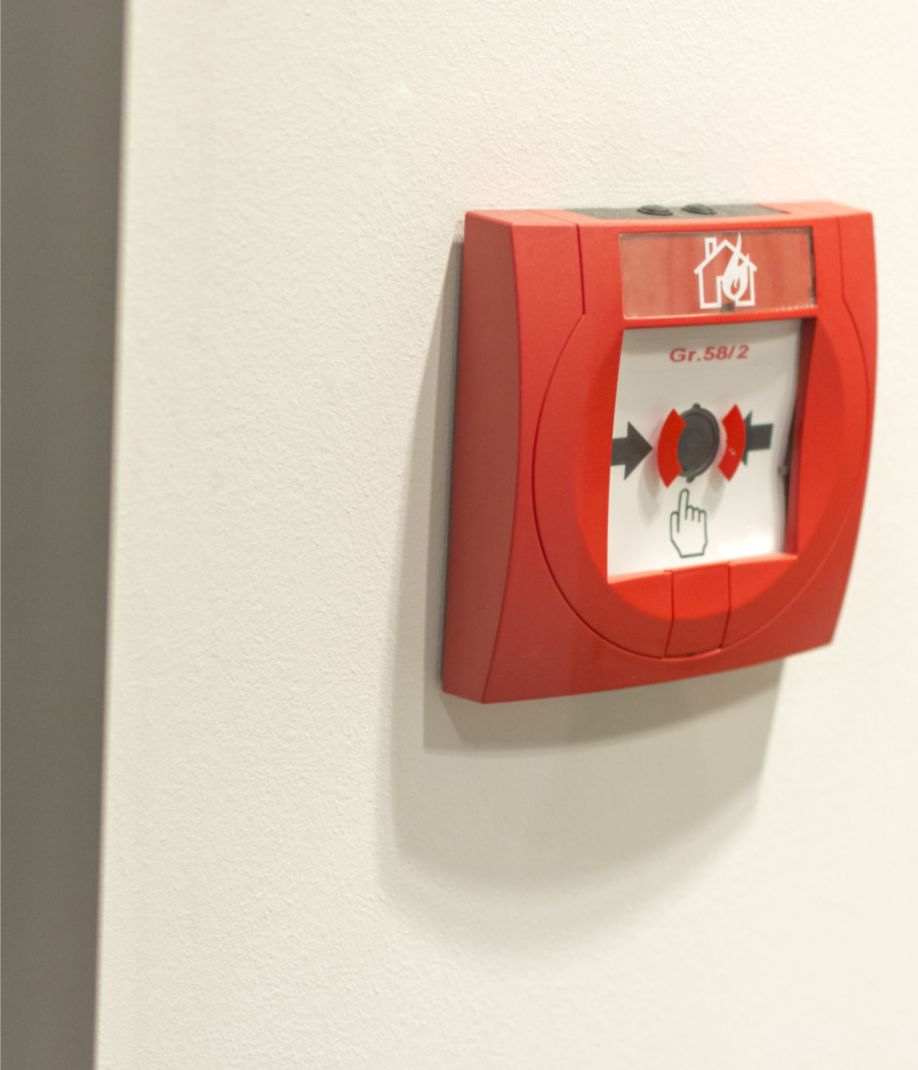 Rote Brandmeldeanlage an der Wand montiert, bereit zur Alarmierung im Notfall.